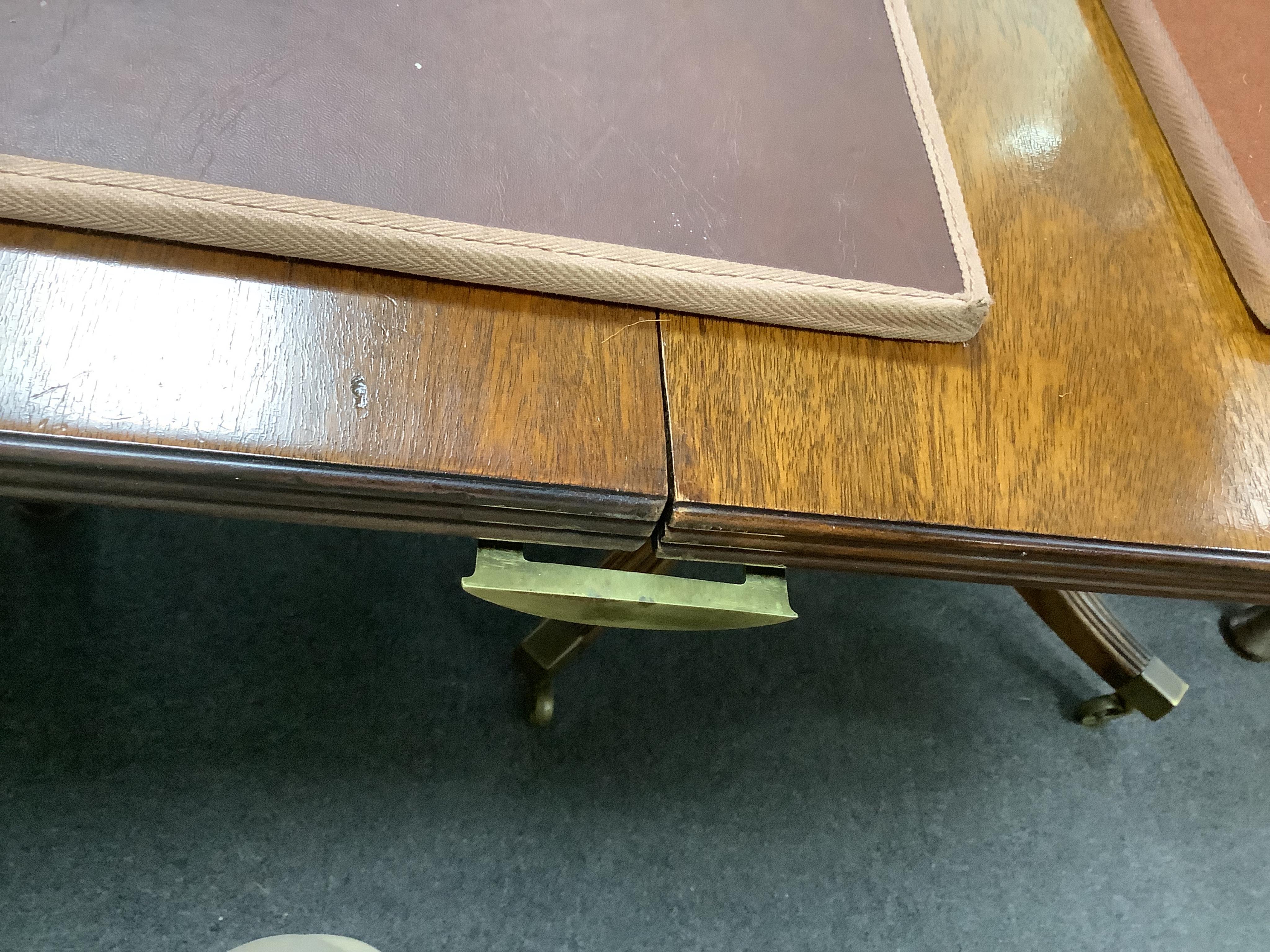 A Regency style mahogany twin pillar extending dining table, width 295cm extended, two spare leaves, depth 114cm, height 74cm
